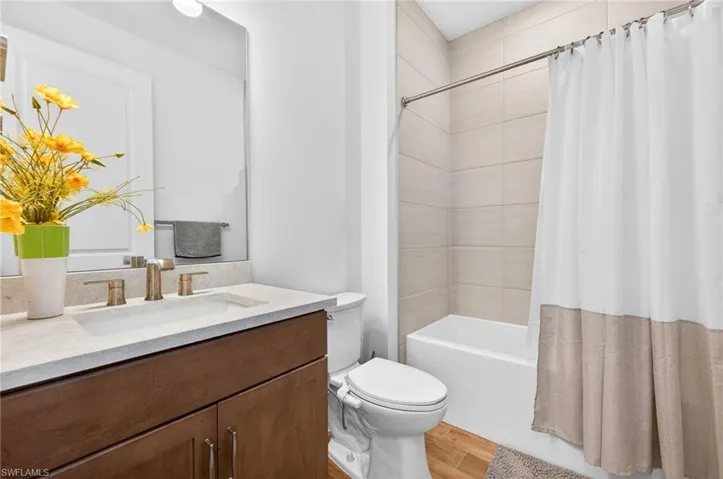 Full bath featuring vanity, light wood finished floors, and shower / bath combination with curtain