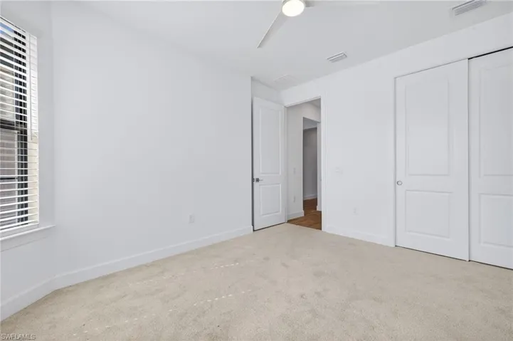 Unfurnished bedroom with carpet flooring, ceiling fan, and a closet