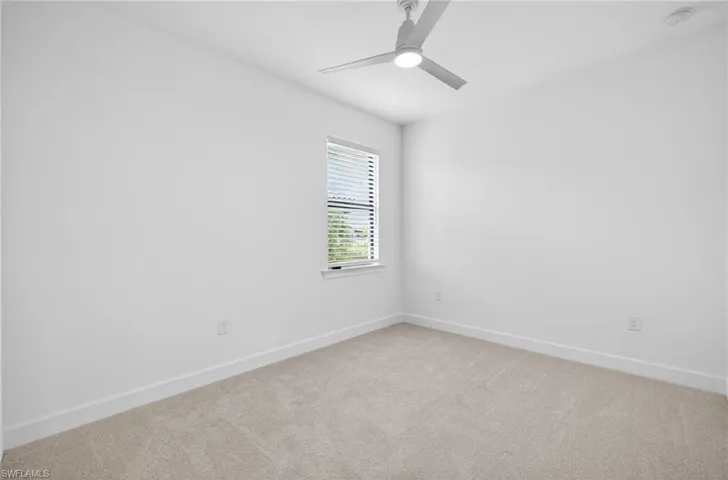 Carpeted empty room with baseboards and ceiling fan