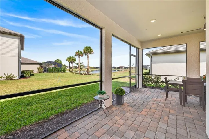 Sunroom featuring a water view, a residential view, and outdoor dining space