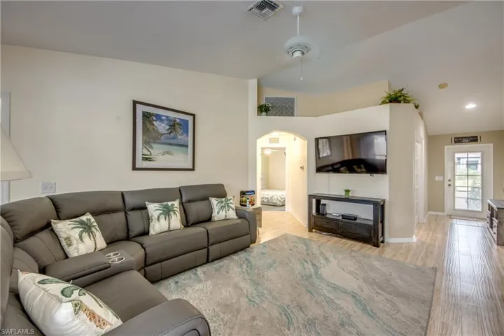 Living room featuring light hardwood / wood-style flooring, ceiling fan, and lofted ceiling