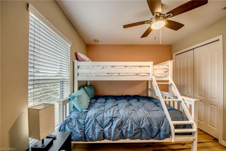 Bedroom with ceiling fan, a closet, and light hardwood / wood-style floors