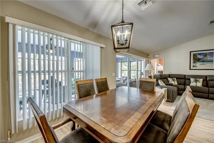 Dining space with a chandelier, hardwood / wood-style flooring, and lofted ceiling