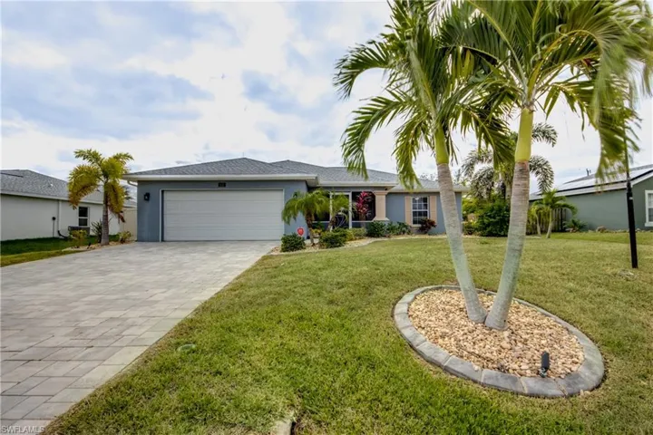 Single story home featuring a front yard and a garage