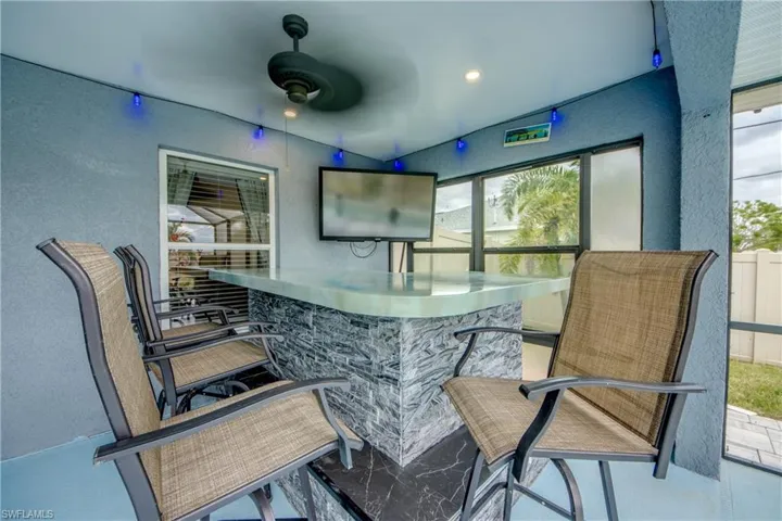 Bar featuring stainless steel counters, plenty of natural light, and ceiling fan