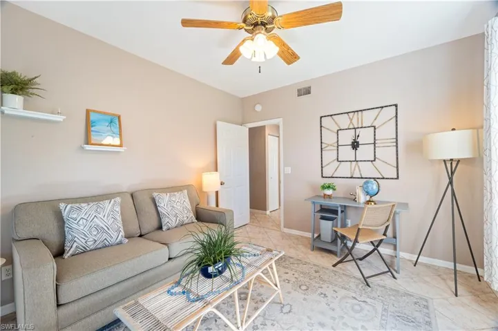Living room with tile patterned floors and a ceiling fan