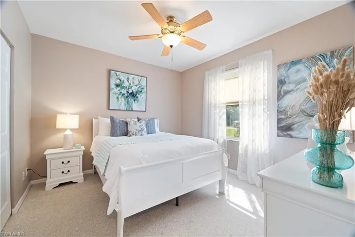 Bedroom featuring light colored carpet and a ceiling fan