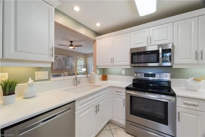 Kitchen featuring appliances with stainless steel finishes, recessed lighting, white cabinets, a ceiling fan, and light tile patterned floors