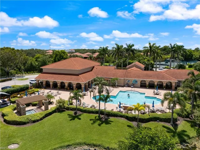 Community pool featuring a patio area, a pergola, and view of scattered trees
