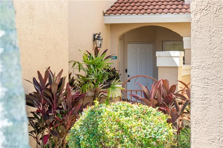 Entrance to property with a tiled roof and stucco siding