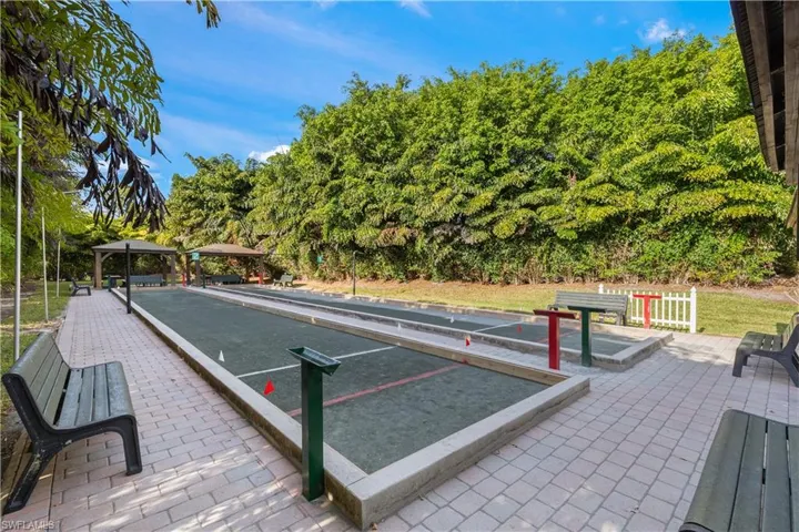 View of property's community with a game area, a patio, a gazebo, and view of scattered trees
