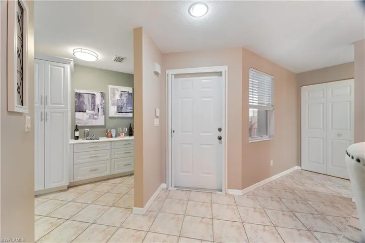 Entryway featuring light tile patterned flooring and a textured ceiling
