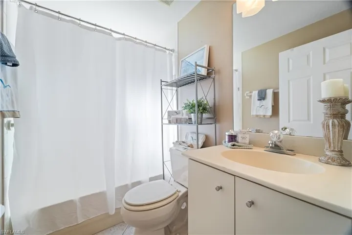 Bathroom with shower / tub combo, vanity, and light tile patterned floors