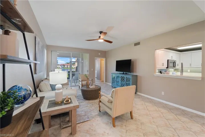 Living room with light tile patterned flooring and ceiling fan