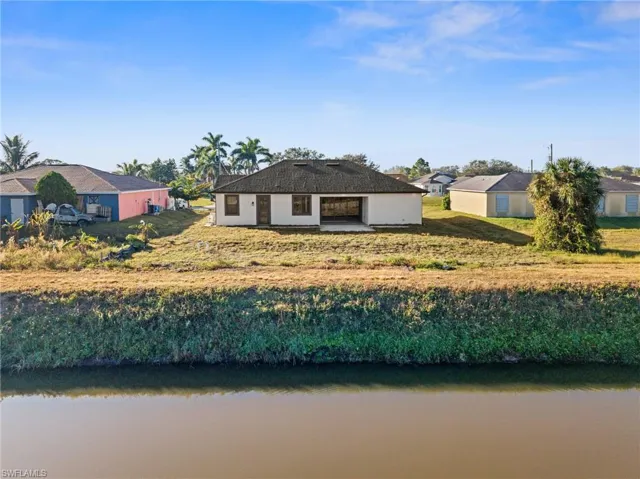 Back of house featuring a water view and a yard