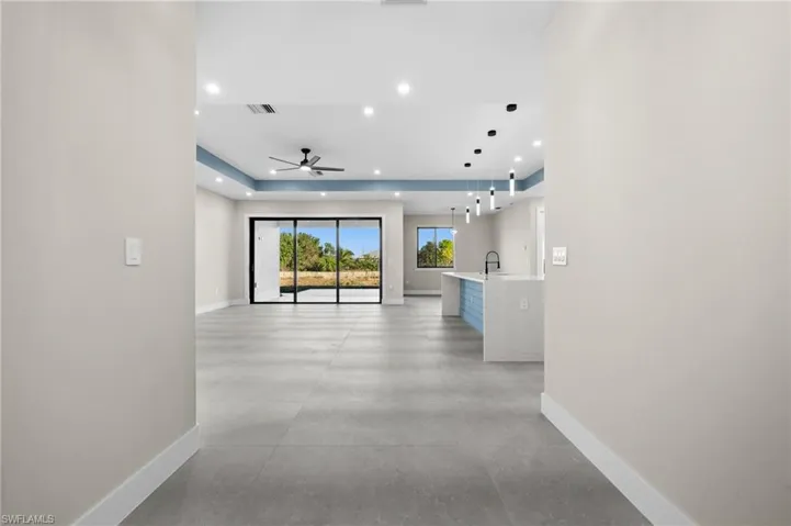 Hallway featuring a raised ceiling and sink