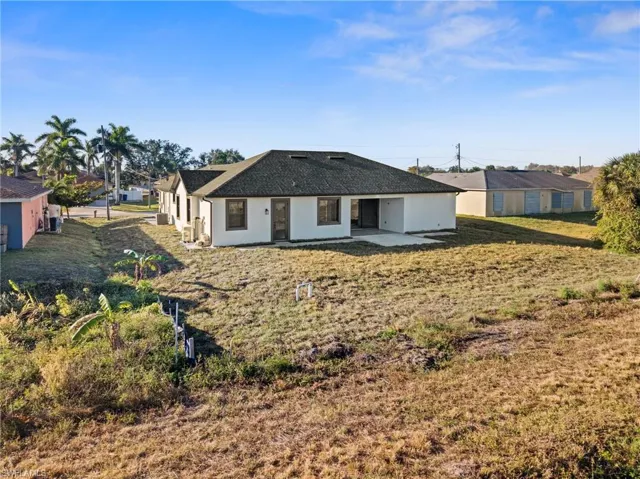 Rear view of property with a patio and a lawn