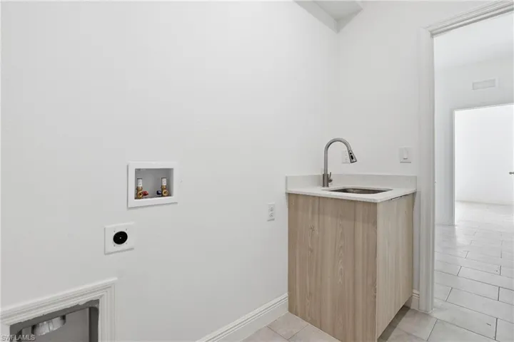 Washroom featuring light tile patterned floors, washer hookup, and electric dryer hookup