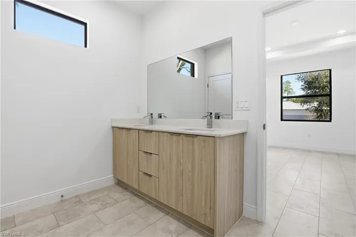 Bathroom featuring double vanity and light tile patterned flooring
