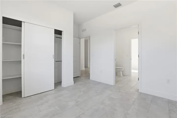 Unfurnished bedroom featuring a closet and connected bathroom