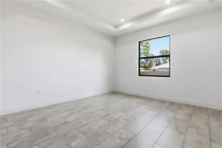 Empty room with a tray ceiling and recessed lighting