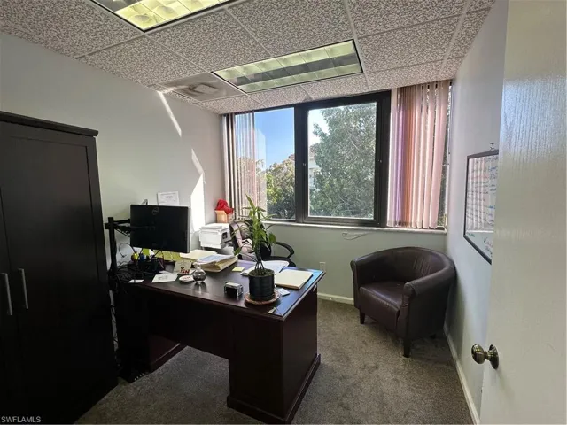 Carpeted office featuring a drop ceiling