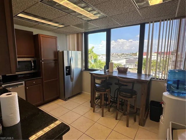 Kitchen with dishwasher, light tile patterned flooring, and refrigerator