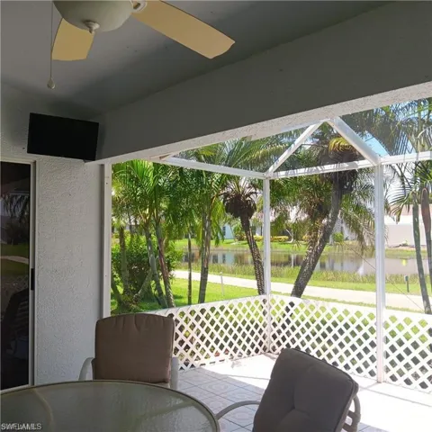 Sunroom with ceiling fan and a water view