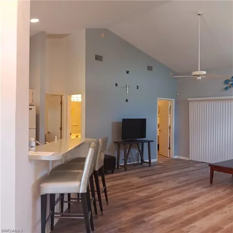 Dining room with ceiling fan, high vaulted ceiling, and hardwood / wood-style flooring