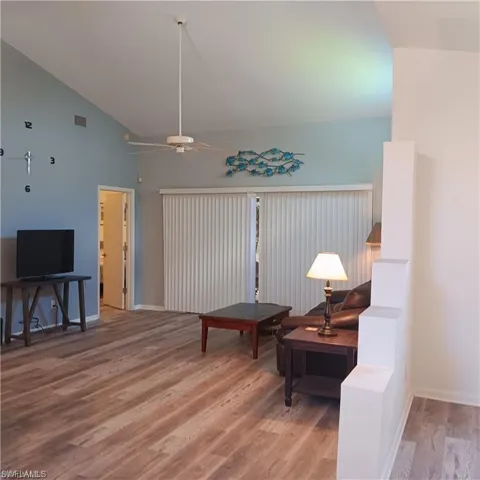 Sitting room featuring ceiling fan, high vaulted ceiling, and hardwood / wood-style floors