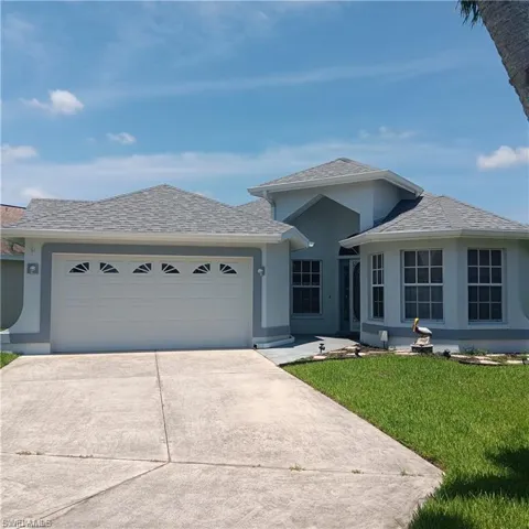 View of front of property with a garage and a front lawn