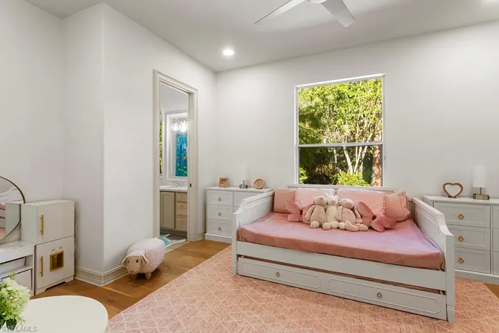 Bedroom with light wood-type flooring, ceiling fan, recessed lighting, and ensuite bathroom