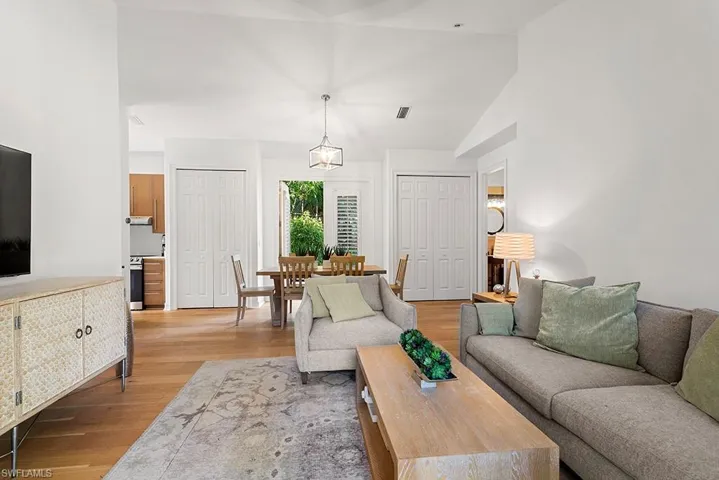 Living room with light wood-style flooring and lofted ceiling
