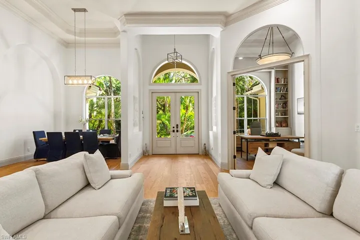 Living room featuring crown molding, healthy amount of natural light, light wood finished floors, and french doors
