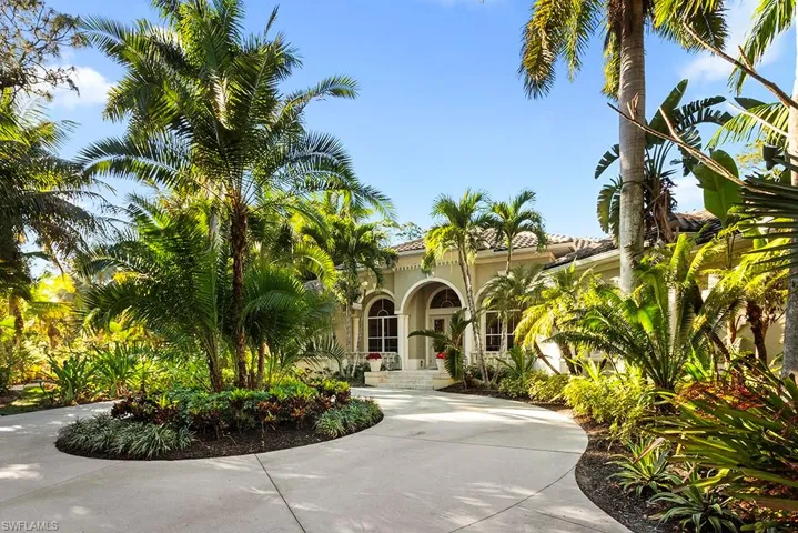View of front of property featuring stucco siding and curved driveway