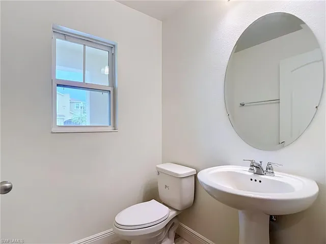 Half bath off foyer by front door and garage entry door