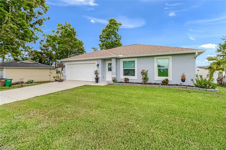 Ranch-style house with a garage and a front yard