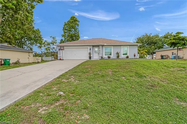Single story home with a front yard and a garage