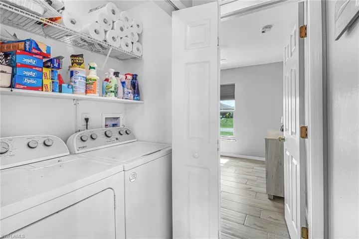 Clothes washing area featuring separate washer and dryer, washer hookup, and light hardwood / wood-style flooring
