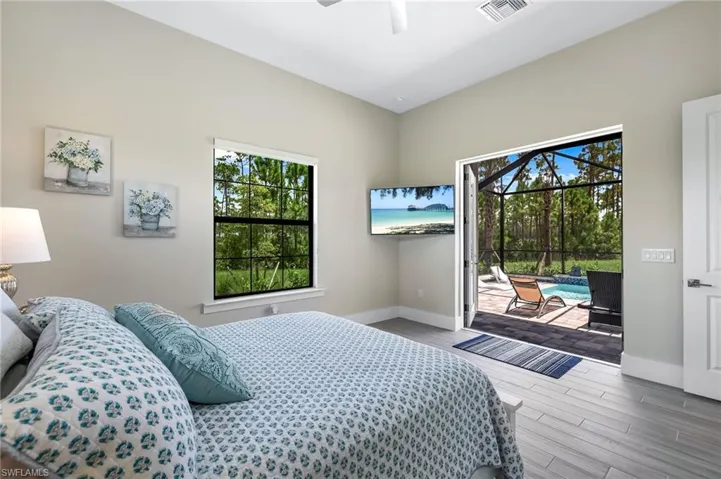 Bedroom featuring ceiling fan, access to outside, multiple windows, and hardwood / wood-style floors