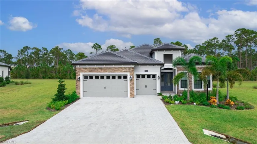 View of front of property with a garage and a front lawn