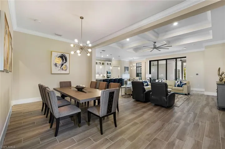 Dining space with coffered ceiling, ornamental molding, hardwood / wood-style flooring, and beam ceiling