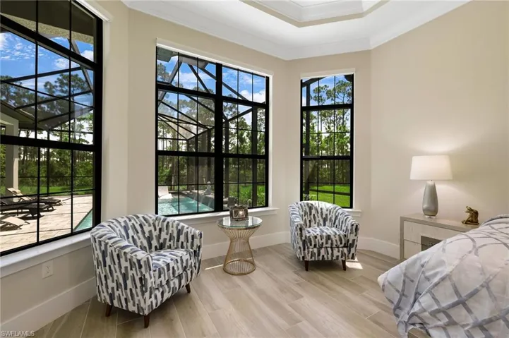 Bedroom with multiple windows, light hardwood / wood-style floors, and ornamental molding