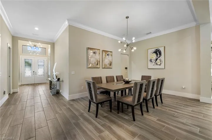 Dining space featuring french doors, a chandelier, and ornamental molding