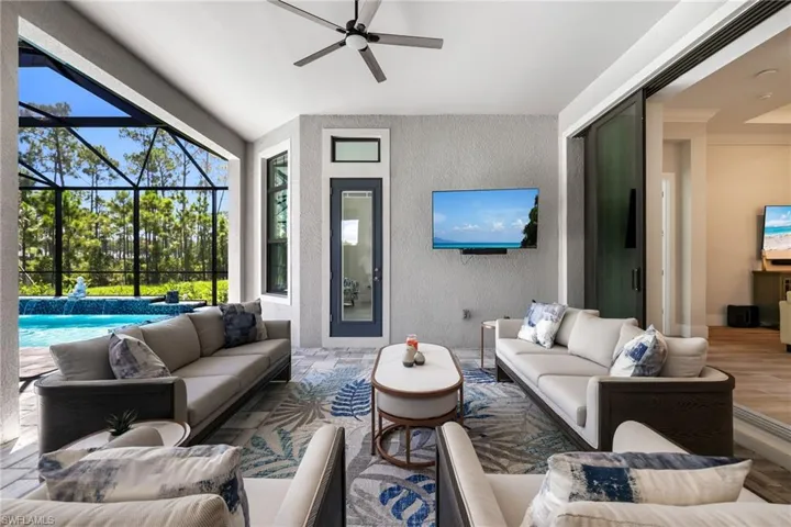 View of patio with glass enclosure, ceiling fan, and an outdoor living space
