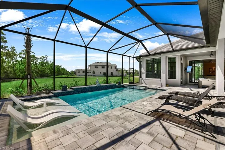 View of swimming pool with a lanai, a lawn, and a patio area