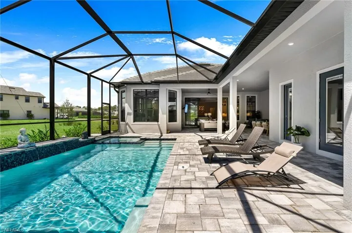 View of swimming pool with glass enclosure and a patio