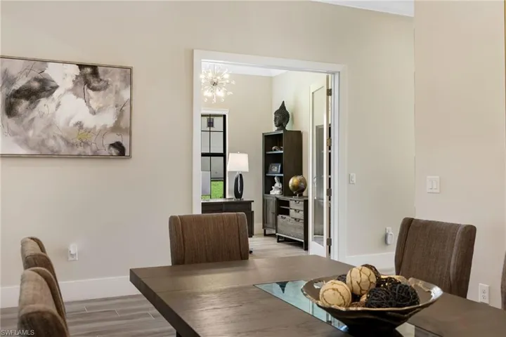 Dining space with light hardwood / wood-style flooring and an inviting chandelier