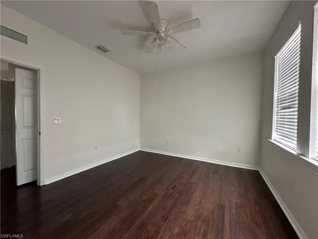 Spare room featuring dark hardwood / wood-style floors and ceiling fan