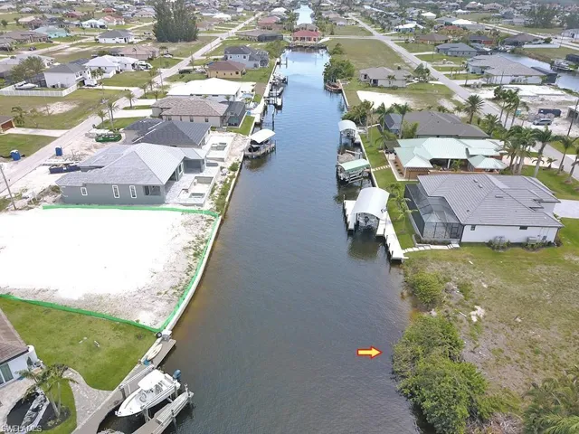 Aerial view of property's location featuring a nearby body of water and nearby suburban area